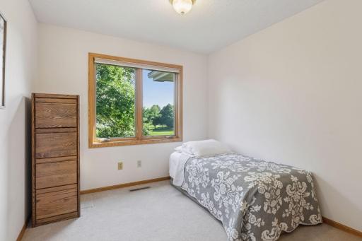 Upper-level bedroom with serene views of the backyard.