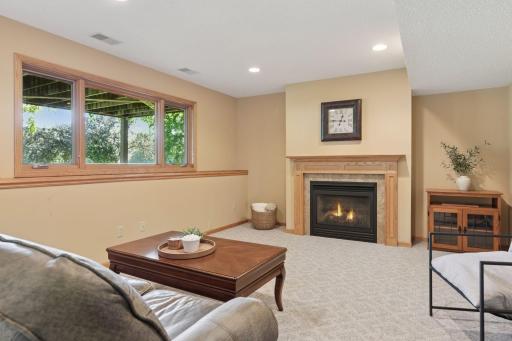 The lower-level recreation room is a comfortable retreat to relax by the fireplace and enjoy time with family and friends.