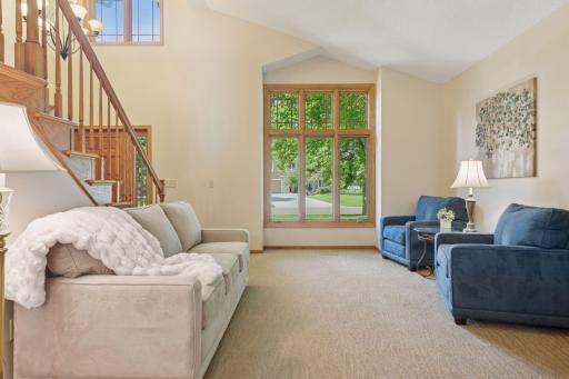 Dramatic two-story ceilings in the living room and foyer create a bright and open atmosphere.