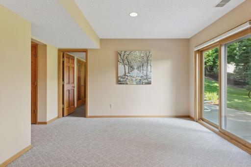 The lower-level recreation room provides ample space to easily accommodate a future wet bar, along with plenty of room to arrange additional tables and seating-perfect for hosting gatherings and entertaining guests with ease.