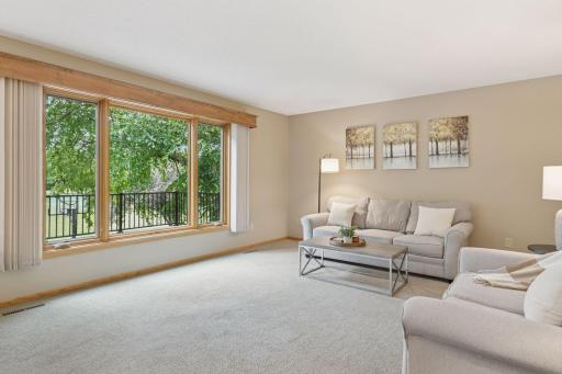 A warm and inviting family room where natural light from the large picture windows, fills the space and peaceful views of the backyard and golf course create a true sense of home.