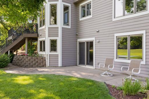 The walkout lower-level patio provides additional outdoor living space, perfect for relaxing or entertaining while enjoying serene views of the backyard and golf course.