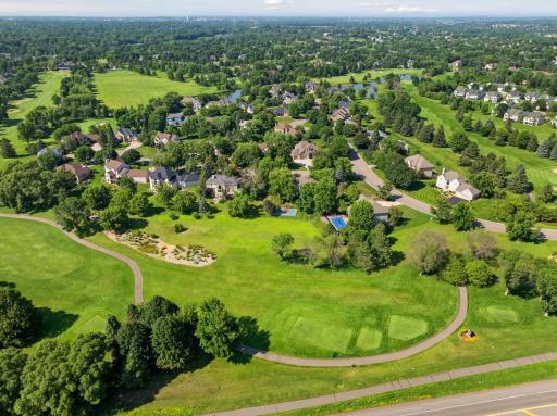 A stunning aerial view of the back of the home in Wedgewood Estates, showcasing the beautifully landscaped property and the signature 16th hole at Prestwick Golf Course.