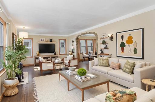 Open, spacious living room has a gas-insert fireplace and built in cabinets under the double windows. Virtually staged