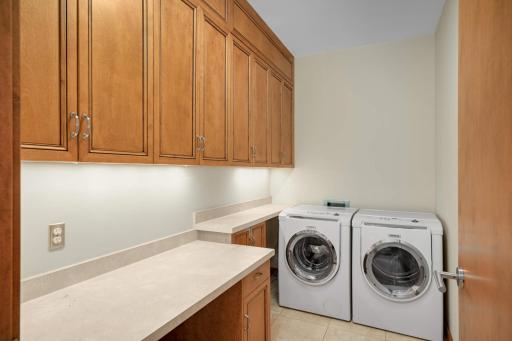 The adjacent laundry room offers a desk space and an abundance of cabinerty