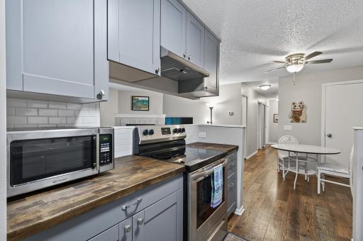 The kitchen features freshly-finished butcher block countertops and stainless steel appliances.