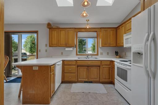 Enjoy cooking with backyard views from the kitchen sink, framed by oak cabinetry and natural light. Counter seating adds convenience for quick meals.
