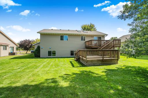 Dual decks provide multiple outdoor living areas with easy access to the lush yard, ideal for family gatherings or relaxing evenings.