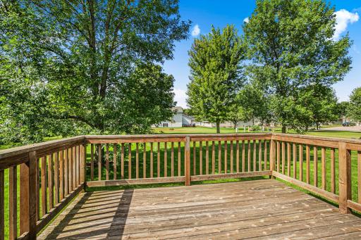 The upper deck offers beautiful tree-lined views of the neighborhood green space, creating a perfect spot for outdoor dining.