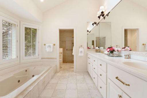 The primary bath includes expanded shower with seating, travertine marble, new hardware and vaulted ceilings