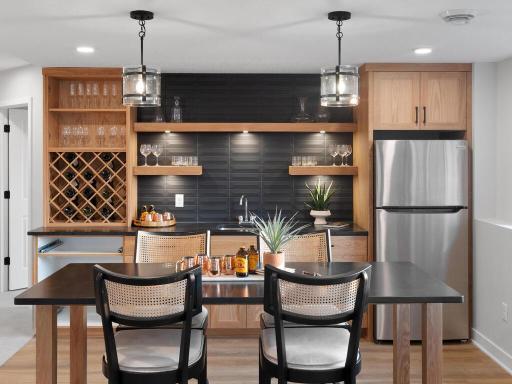 Stylish black tile, countertops look classy and wine storage.