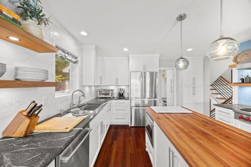 A chef's dream kitchen with Wolf and Bosch appliances, floor to ceiling cabinetry and floating shelves