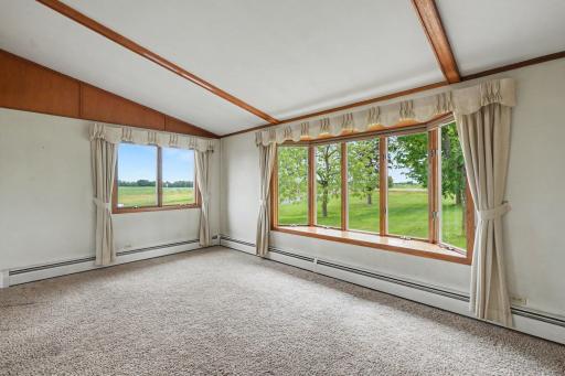 The spacious living room features beautiful ceiling beams, a large bay window, and a convenient coat closet. The soaring 9' vaulted ceiling. The home includes Anderson windows.