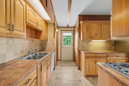 The kitchen features beautiful hickory cabinets, ceramic tile floors & backsplash, a double stainless sink and abundant counter & storage space. In the back of the kitchen, you'll find a 1/2 bath and convenient access to the large deck & lower level.