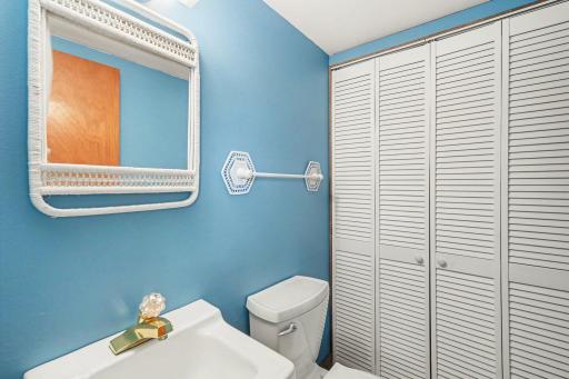 This main-level half-bath offers ultimate convenience, featuring a large storage closet and a prime location right next to the backyard deck accessâperfect for quick cleanups after spending time outdoors enjoying the view of your 2.43 acres.
