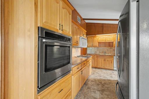 Another view of the kitchen highlighting the hickory cabinets and ceramic tile floors.