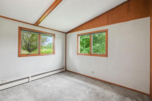 Bright and spacious second main-level bedroom features a decorative wood beam, generous closet space, and dual windows that maximize natural light. Conveniently located near the 3/4 bath.