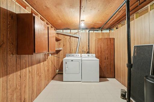 The laundry room includes a newer washer and dryer and plenty of storage space.