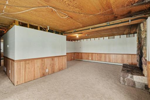 Another view of the spacious family room with a stone wood fireplace. The home includes two 100-amp electrical panels and ancillary fuses in the garage.