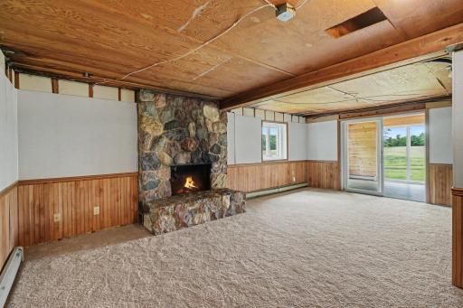 The lower-level features a spacious family room with a wood fireplace and a sliding door leading to the beautiful sunroom. A perfect place to entertain.