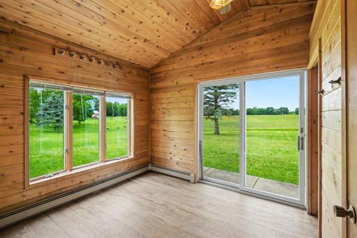 Ultimate relaxation awaits in the sunroom, wrapped in beautiful knotty pine. Features luxury vinyl tile floors, a ceiling fan, a convenient half-bath, and bonus storage, all with immediate access out to your gorgeous 2.43 acre lot with mature trees.