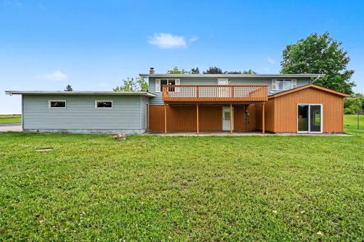 A view of the house showcasing the deck and patio. Some key updates include roof 2025, furnace/AC 2024, water softener 2024, refrigerator & wall oven 2022. The compliant septic pumped every 3 years. Driveway resurfaced every 5 years.