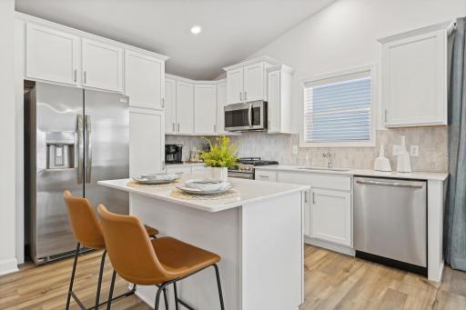(Photo of a model home, finishes will vary) The chef-inspired kitchen showcases and elevated design, overlooking the dining room and Great Room and equipped with new appliances and a large center island that adds bar-style seating.