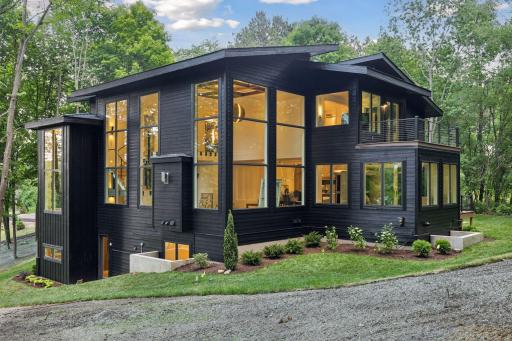 The open-concept features a great room with soaring 20 foot ceilings, wood beams, and V-groove accents that create a warm interior aesthetic.