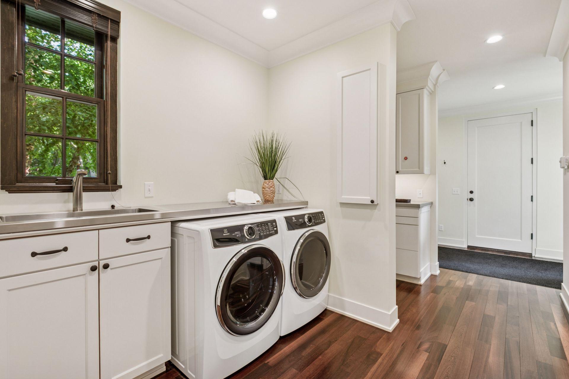 The laundry room is conveniently located off of the garage and kitchen and features Electrolux washer and dryer, stainless countertop (makes for a great overflow food area when entertaining) and sink, built-in ironing board and utility closet.