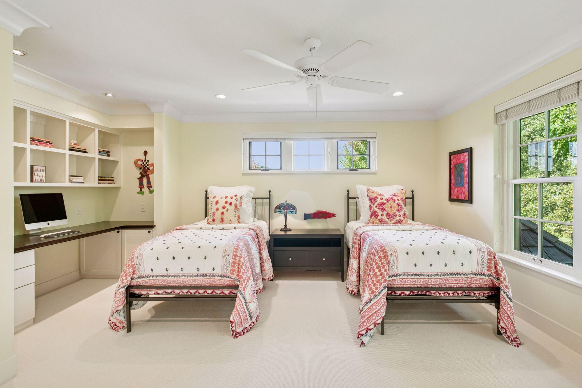 3rd bedroom upstairs can easily accommodate 2 beds, complete with a built-in desk and shelving and a walk-in closet.