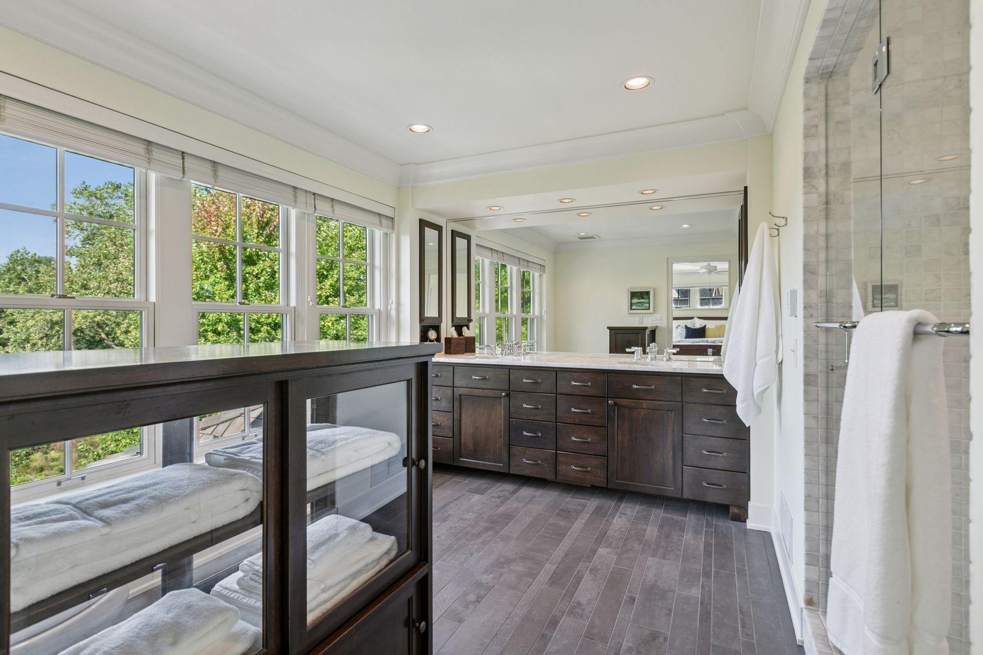 Luxurious primary bath features a custom 36' vanity with marble countertops and double undermount sinks, heated porcelain floors, marble shower surround with dual shower heads and frameless shower doors.