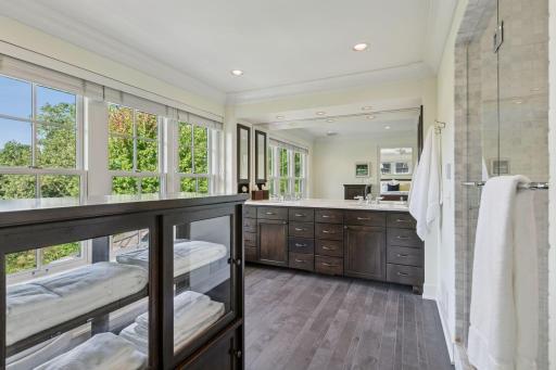 Luxurious primary bath features a custom 36' vanity with marble countertops and double undermount sinks, heated porcelain floors, marble shower surround with dual shower heads and frameless shower doors.