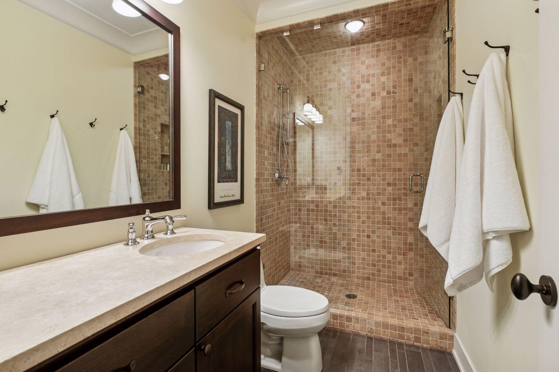 3/4 bath featuring commercial grade porcelain floors (heated) and limestone countertops and shower surround.