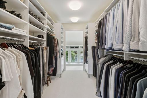 Walk-in dressing room with built-in hanging bars and shelving.