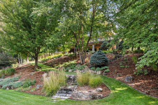 Low maintenance landscaping with thoughtfully planned perennial gardens and stone steps to the lower yard and playspace.