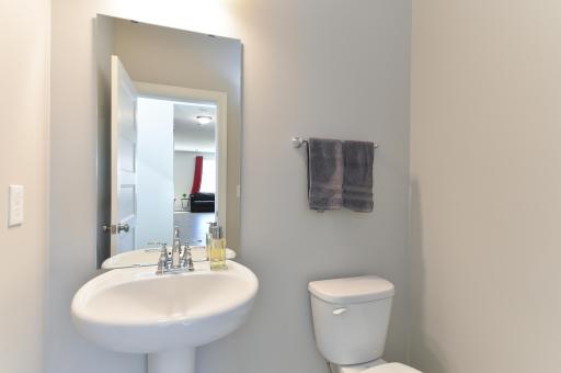 Conveniently located bathroom right off the main level foyer features a classic pedestal sink.