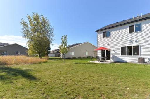 Enjoy a low-maintenance backyard with a grassy area, a few small trees, and plenty of sunshineâperfect for a bit of outdoor relaxation.