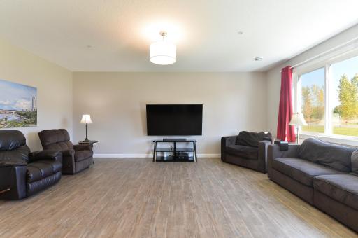 The main level living room is open and bright with hard surface flooring and an oversized window that lets in plenty of natural light.