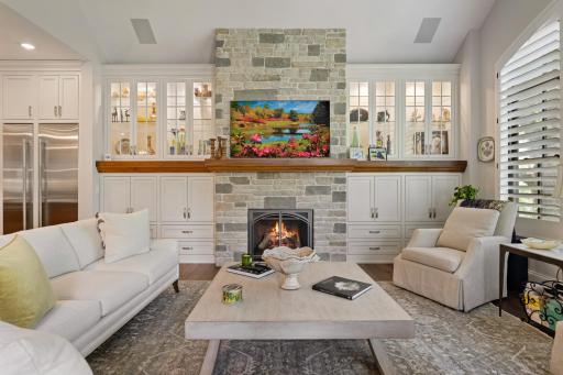Custom and lit built-in cabinets framing the fireplace