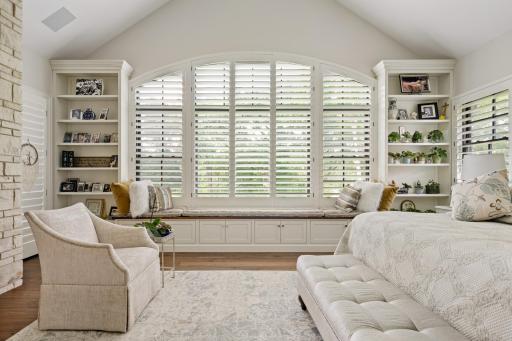 Custom built-ins and storage bench frame the massive arched window