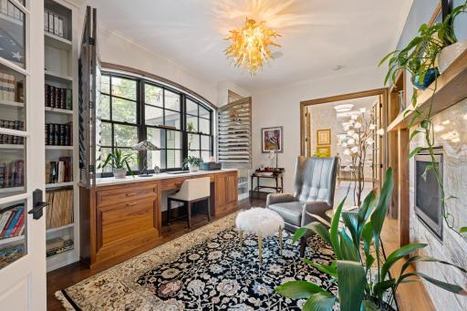 Just off the banquette booth through french doors is a formal office with a large arched window and custom shutters