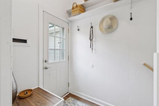 Freshly painted side entry door with a new storm door leads you to the detached garage.