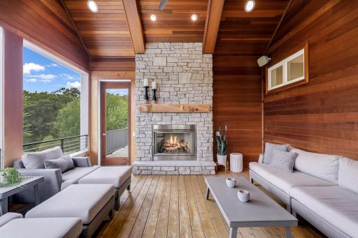 3-season vaulted screened porch with stone fireplace with tongue and groove cedar ceiling and walls