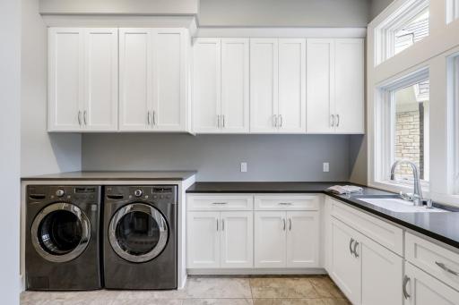 The bright main level laundry room /mudroom offers storage galore and is located off of the kitchen