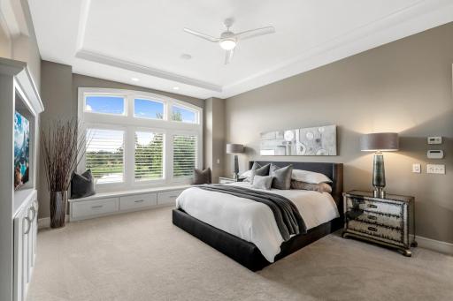 Primary bedroom with tray-vaulted ceiling and bay windows