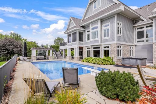 Shimmering saline pool with diving board, retractable electric cover and and new liner in 2025. Hot tub is new in 2022. Opposite from the pool is the poolside pergola to catch some shade.