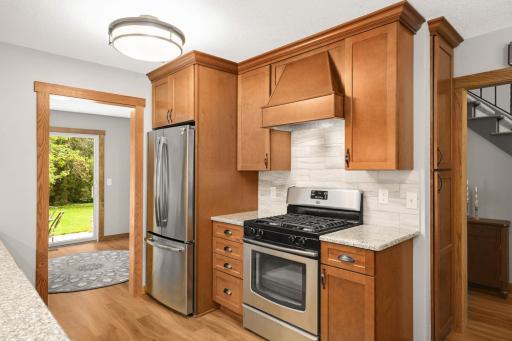 Modern kitchen features stainless steel appliances and a designer hood vent