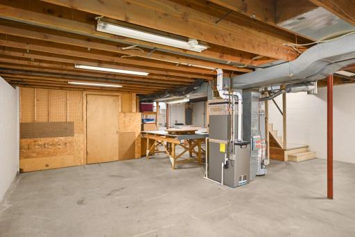 Newer mechanicals including furnace, AC, water heater, and electrical panel with whole home surge protection