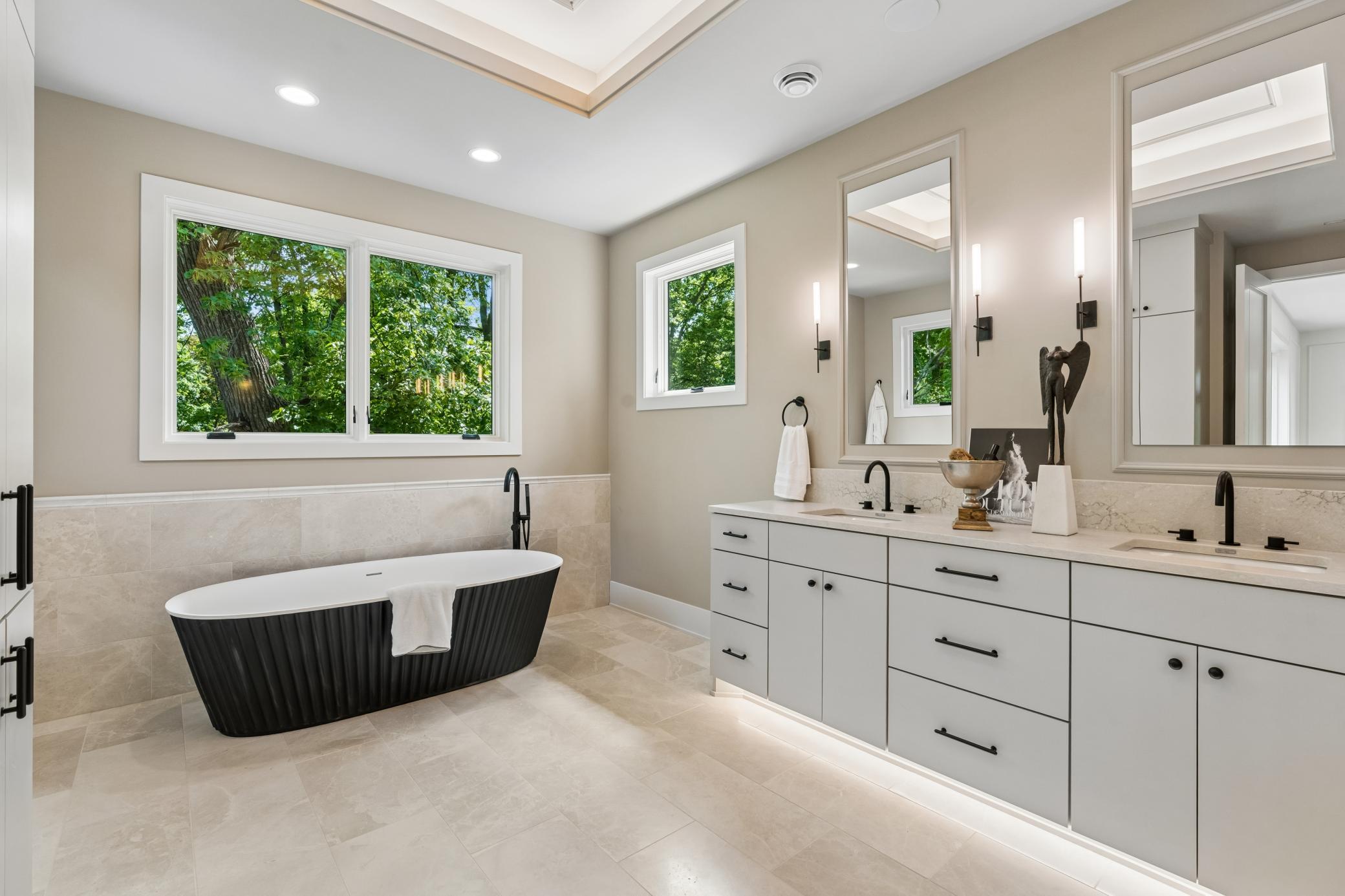 stunning master bathroom featuring stand alone tub fully clad with marble and cambria countertops
