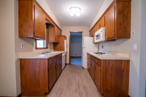 Galley kitchen with new flooring and in formal dining area. Plenty of room for storage as well as cooking. All appliances stay with home.